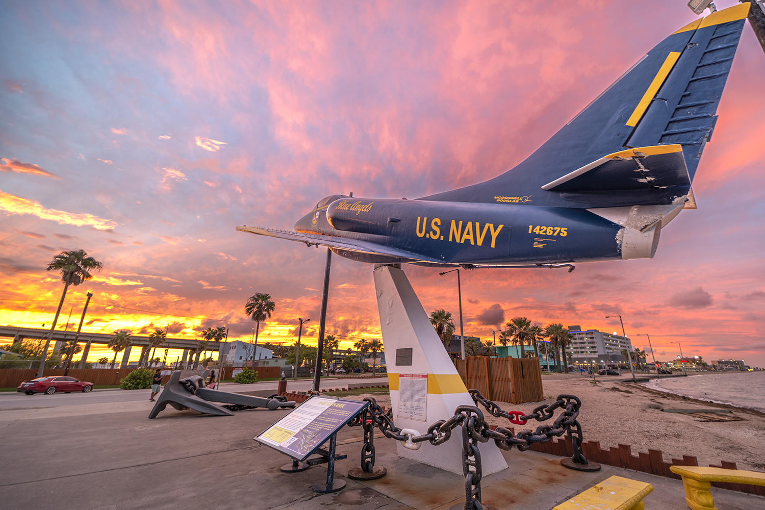 Blue Angels A-4 Skyhawk display overlooking North Beach in Corpus Christi during a colorful sunset.